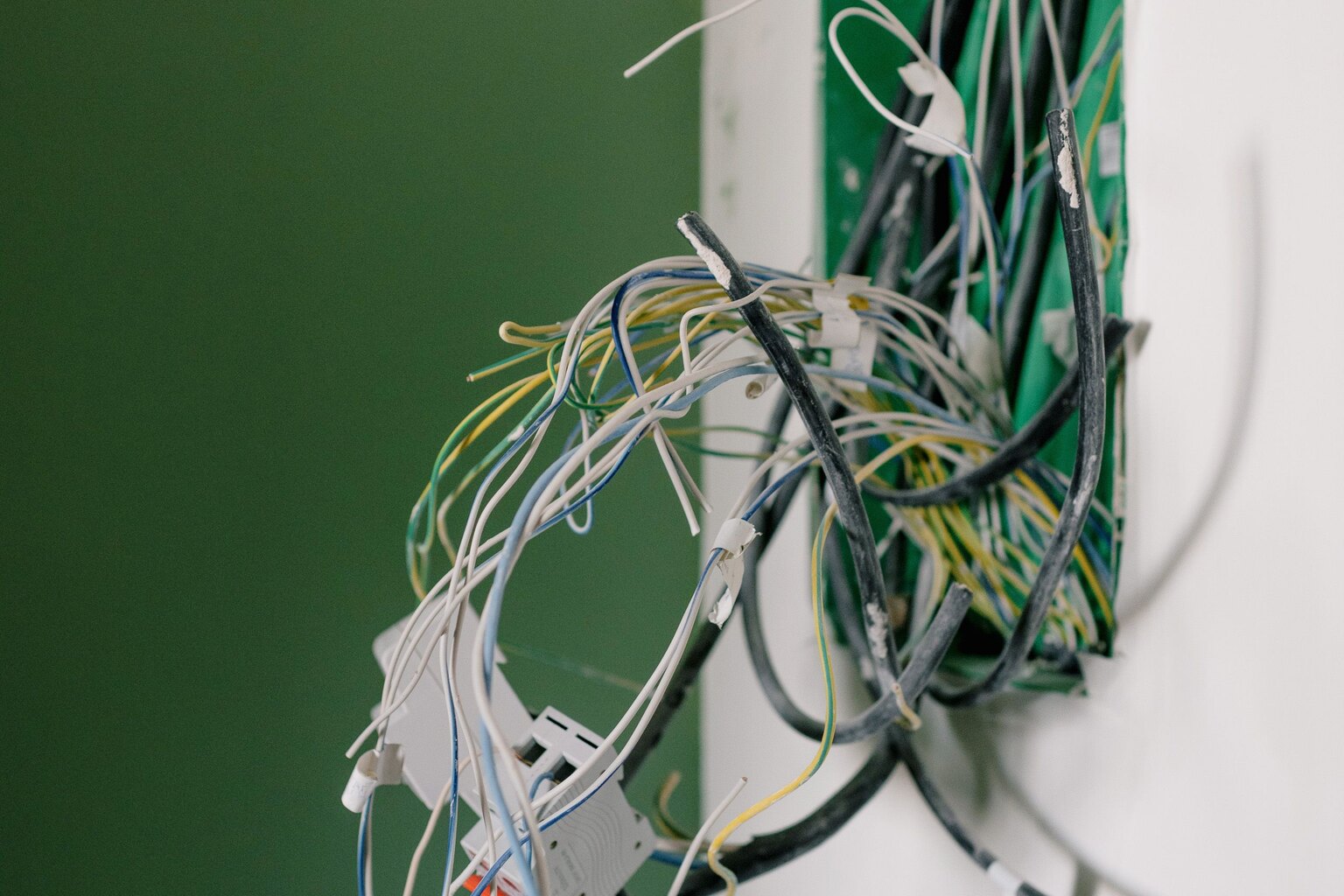 Electrical cables being routed into a wall during a rewire